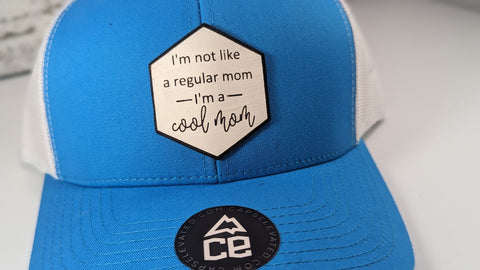 I'm not like a regular mom I'm a cool mom White leather patch trucker hat